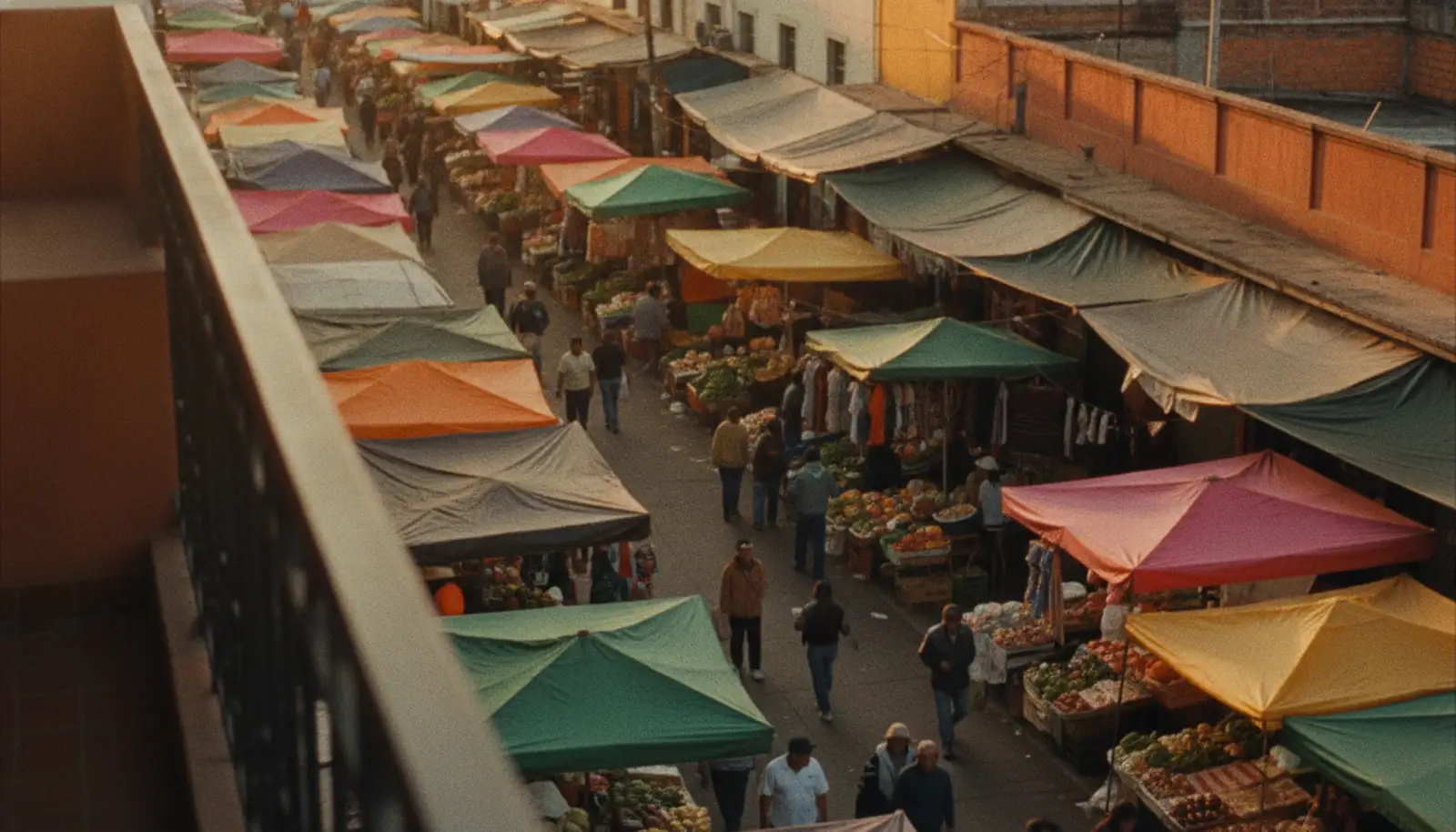 Feira de rua ao entardecer, com barracas coloridas e pessoas caminhando entre elas